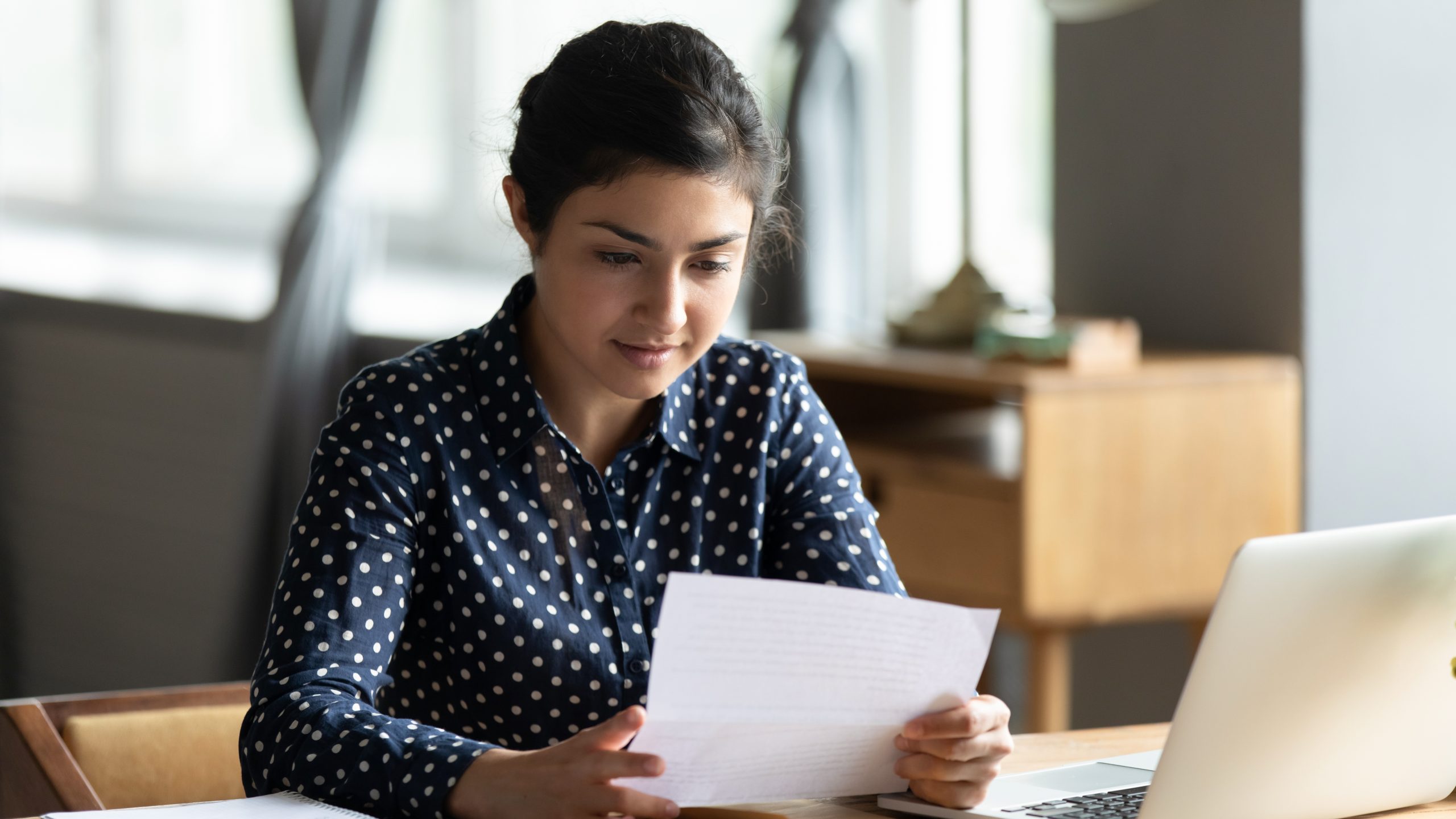 Woman reading a printed accommodation letter generated automatically by her system.